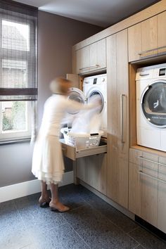 a woman is standing in front of a washer and dryer with the words play on it