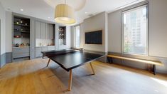 a ping pong table sits in the middle of an empty room with large windows