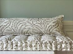 a white and brown bed sitting next to a green wall