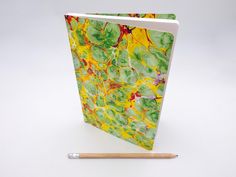 an open notebook sitting on top of a table next to a pencil