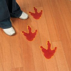 someone standing on the floor with their feet in the air and red handprints