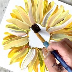 someone is painting a sunflower with watercolors