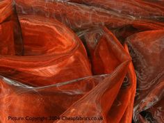 an orange cloth is laying on top of each other in the middle of a pile