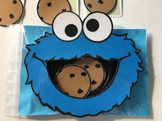 a cookie monster with two cookies in it's mouth on top of a blue bag