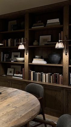 a wooden table sitting in front of a book shelf filled with books