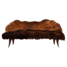 a bench made out of wood and fur with long claws on the top, against a white background