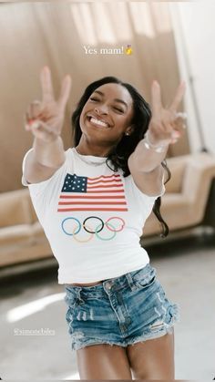 a woman with her hands up in the air and an american flag t - shirt on