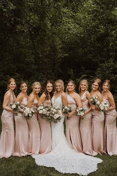 a group of women standing next to each other on top of a lush green field