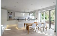 an open kitchen and dining room with sliding glass doors