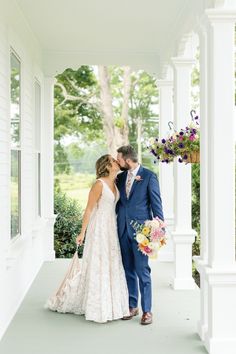 a bride and groom kissing on the porch