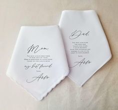 two personalized wedding handkerchiefs on top of a white table cloth with black ink