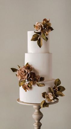 a three tiered white cake with flowers on top