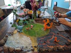 two children playing with toys on a table in front of a large display of plants and animals