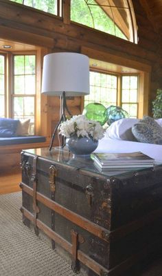 an old trunk sitting on top of a table next to a lamp and couch in a living room