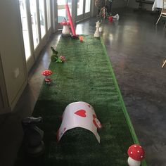 a long green carpet with red and white decorations on top of it in an office building