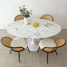 a marble table with four chairs around it and a potted plant in the middle