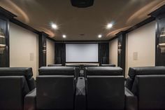 an empty theater room with black leather seats