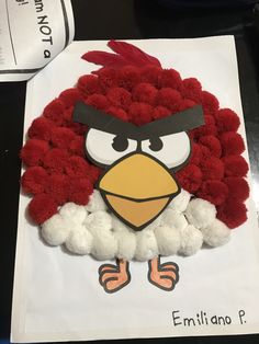 an angry bird made out of pom poms on top of a piece of paper