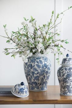 two blue and white vases with flowers in them