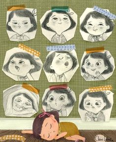 a child is laying on the floor in front of several drawings of children's faces