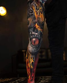 a man's leg with tattoos on it and an image of a skull in the middle