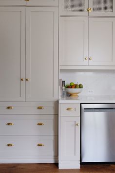 a kitchen with white cabinets and stainless steel dishwasher