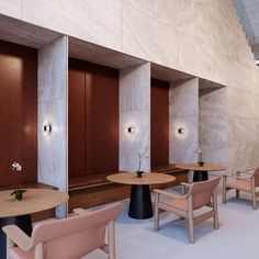 the interior of a restaurant with wooden tables and pink chairs in front of marble walls