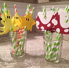 three mason jars filled with paper straws decorated like fish and under the sea creatures