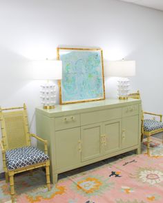 a living room with two chairs and a large painting on the wall above it's dresser