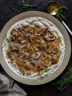 mashed potatoes topped with mushrooms and gravy in a bowl