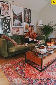 a woman sitting on top of a green couch in a living room next to a coffee table