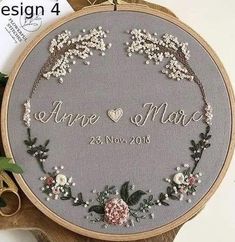 a cross stitch pattern with flowers and leaves on it, in the shape of a wreath