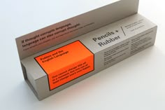 an orange box with some type of writing on the top and bottom, sitting on a white surface