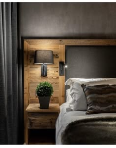 a bedroom with a wooden headboard and night stand next to the bed, along with a potted plant