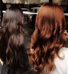 two women with long, wavy hair looking at each other