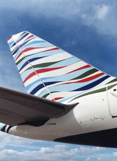 the tail end of an airplane with multicolored stripes