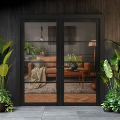 a living room with two couches and potted plants