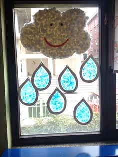 a window decorated with raindrops and a smiley face