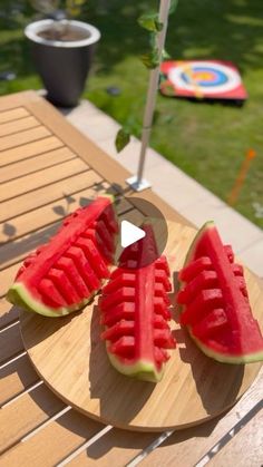 slices of watermelon on a wooden platter with an umbrella in the background