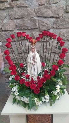 the statue is surrounded by flowers and greenery