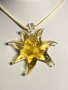 yellow golden glass star, sun pendant, necklace, choker, yellow star, golden sun -PU ivory leather fully adjustable cord choker to long each pendant is handmade and unique.  This color goes with any clothing pendant height: 5.25 cm, 2 1/16 inches +/- 2mm and width: 5 cm, 2 inch +/- 2mm cord length: fully adjustable, choker to 28 inches/71 cm comes with a gift bag designed for someone whom is looking for a unique necklace Please have a look at the other items in my store. I ship all multi-item pu Handmade Adjustable Star Necklace, Handmade Yellow Star-shaped Jewelry, Handmade Yellow Star Jewelry, Adjustable Sun-shaped Jewelry For Gifts, Adjustable Yellow Round Pendant Necklace, Adjustable Yellow Necklace With Round Pendant, Cord Choker, Unusual Clothes, Yellow Star