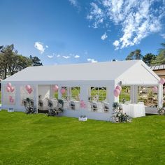 a white tent set up for a wedding with pink and white balloons on the ceiling