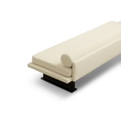 a white bench with black legs on a white background and the seat is upholstered