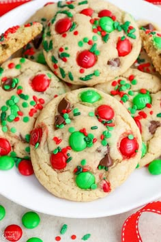 cookies with candy and m & m on a white plate next to christmas candies