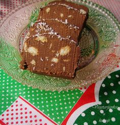 a piece of cake sitting on top of a glass plate next to a green and red table cloth