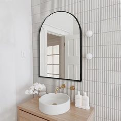 a bathroom with a sink, mirror and soap dispenser on the counter