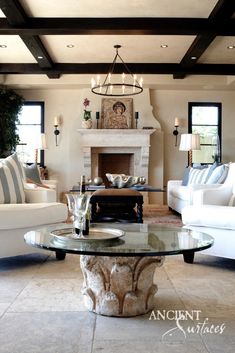 a living room with two couches and a table in front of a fire place