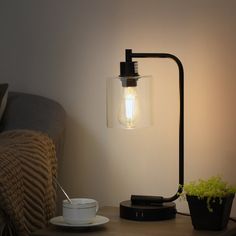 a lamp that is on top of a table next to a cup and saucer