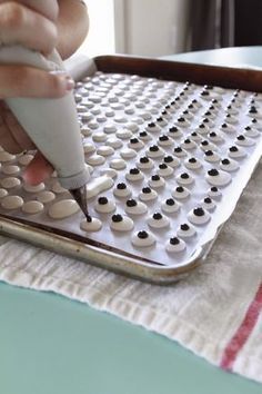 a person is using a pen to draw circles on a sheet of white paper with black dots