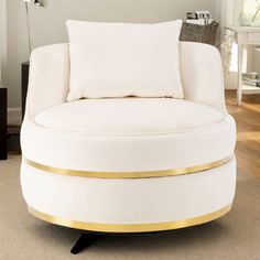 a large white chair with gold trim around the armrests in a living room